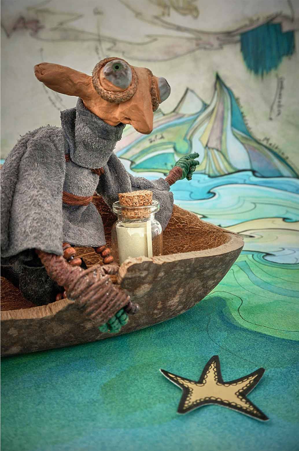 A stop motion character sails in a baobab seed shell boat towards an iceberg with an message in a bottle