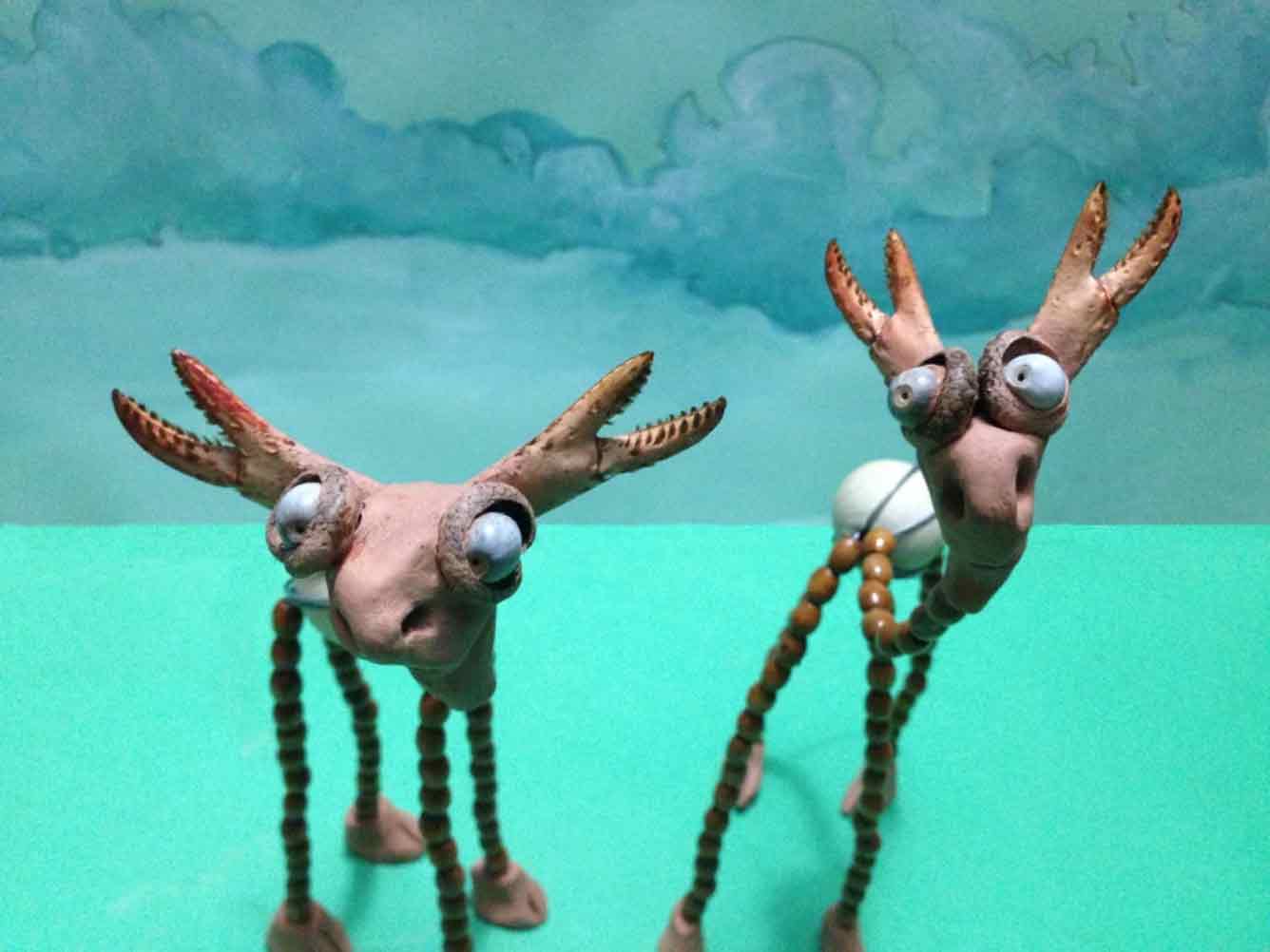 Two Moose-like stop motion characters look surprised in a green meadow on a sunny day.