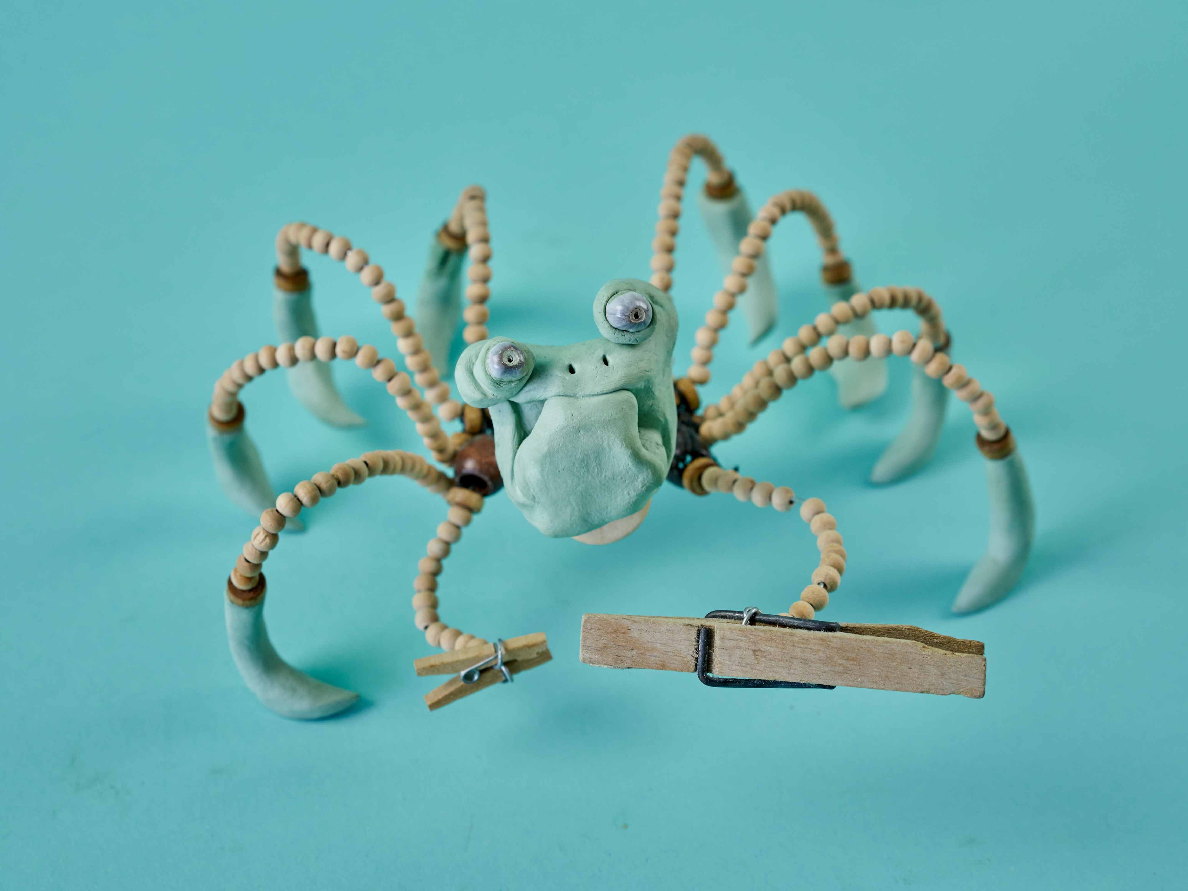 Grumpy Crab character made from green clay, wire, beads and clothespin claw